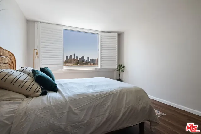 a view of a room with a window and wooden floor