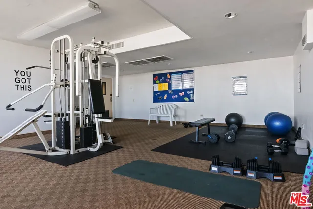 a room with gym equipment and windows