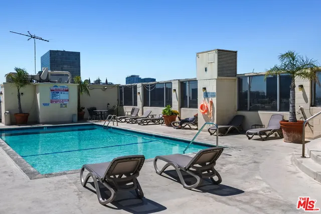 a roof deck view with chairs and potted plants
