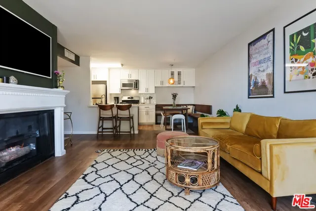 a kitchen with stainless steel appliances a dining table chairs and a refrigerator