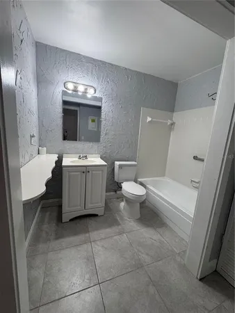 a bathroom with a bathtub sink toilet and mirror