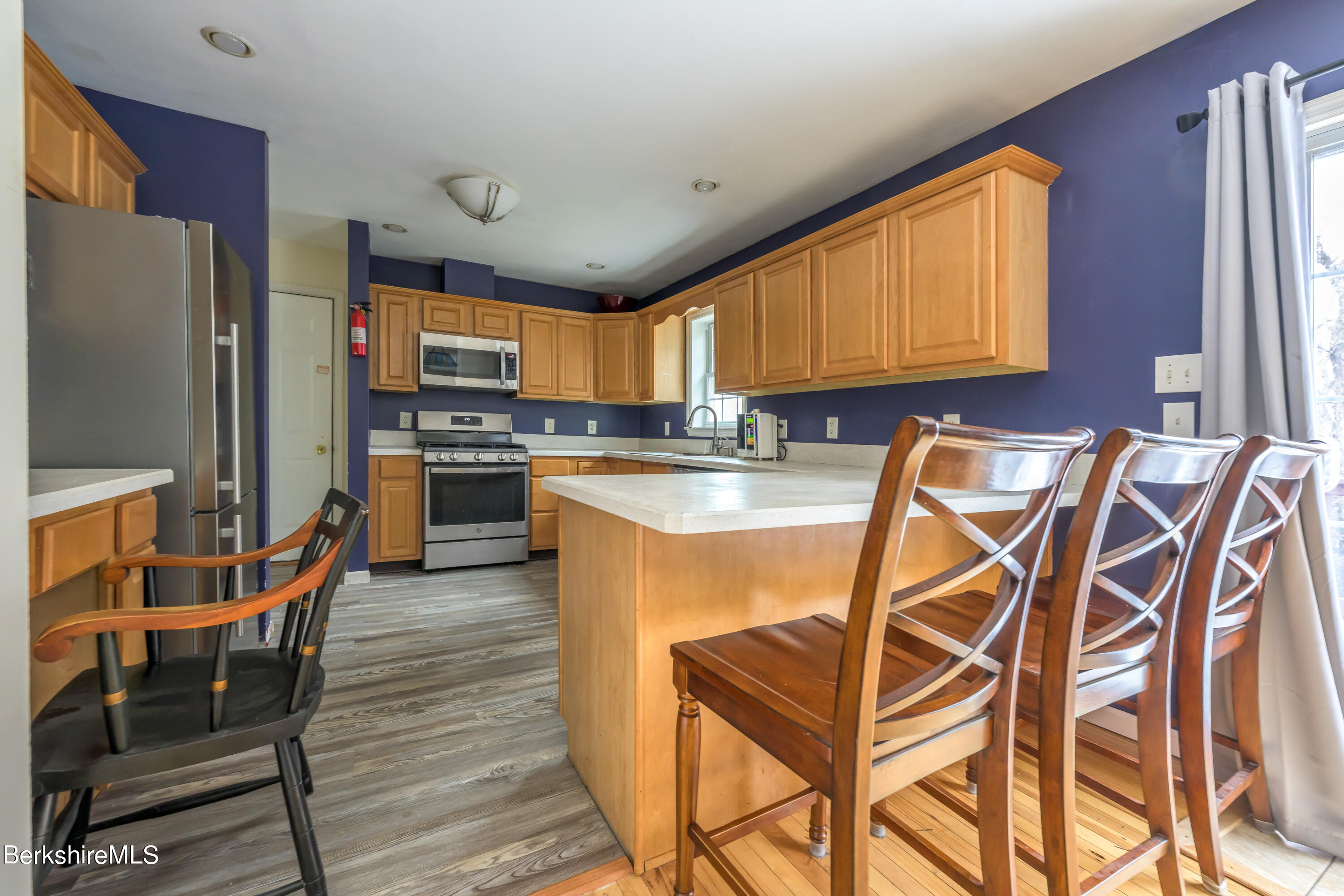 15 Alma Street Pittsfield, MA 01201 - Photo 16 of 35 a kitchen with stainless steel appliances granite countertop a table chairs and a refrigerator