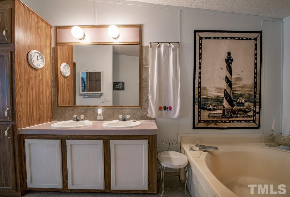 12411 West Old Spring Hope Road Middlesex, NC 27557 - Photo 22 of 28 a bathroom with a granite countertop sink toilet and shower