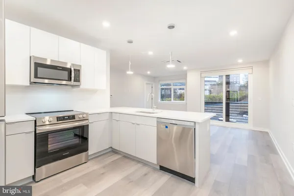 a kitchen with stainless steel appliances granite countertop a stove microwave and sink