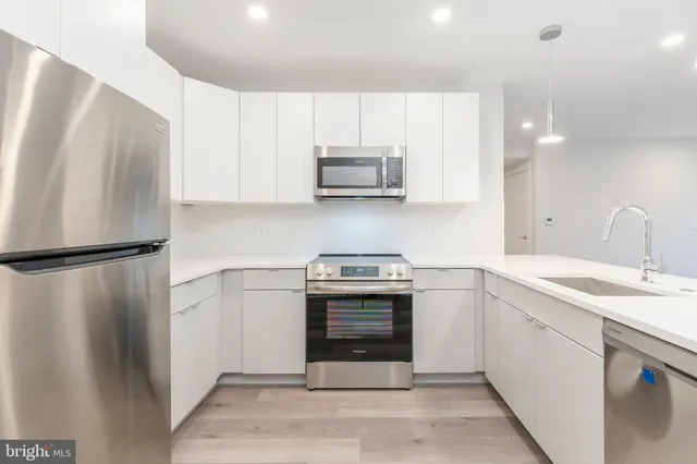 a kitchen with stainless steel appliances granite countertop a refrigerator sink and stove