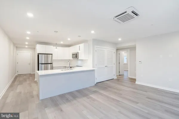 a kitchen with kitchen island a sink stainless steel appliances and cabinets