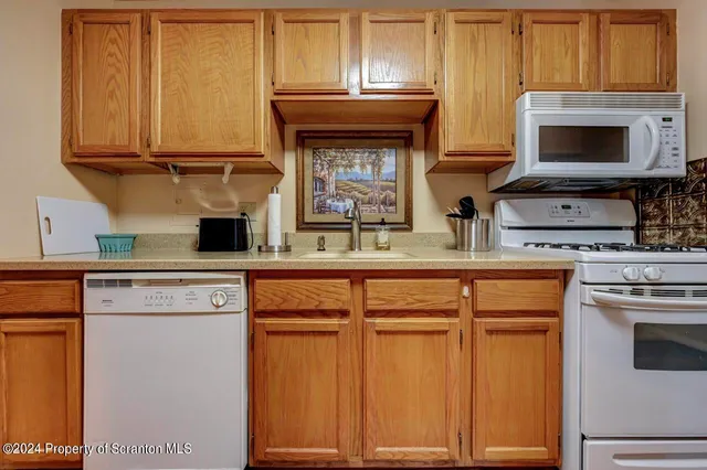 a kitchen with granite countertop a stove top oven microwave and cabinets