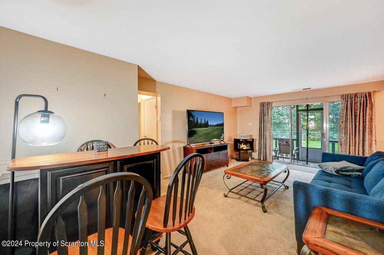 1102 Summit Pointe Scranton, PA 18508 - Photo 15 of 37 a living room with furniture a flat screen tv and floor to ceiling window