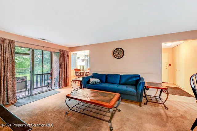 a living room with furniture and a floor to ceiling window