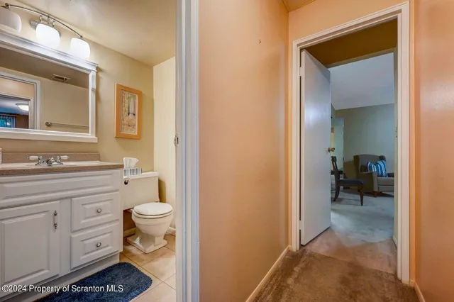 a bathroom with a granite countertop toilet sink and mirror