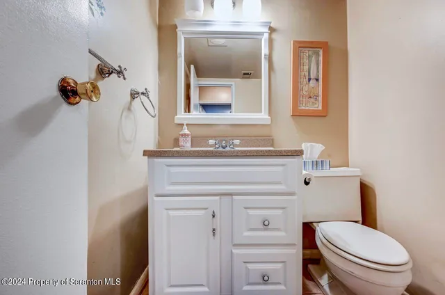 a bathroom with a toilet a sink and mirror