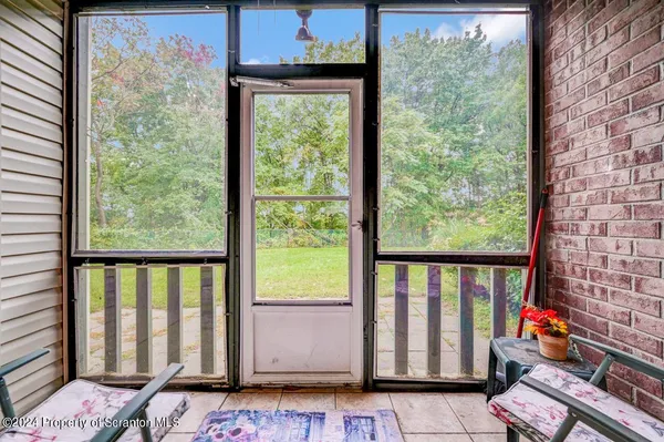 a view of a porch with a table and chairs