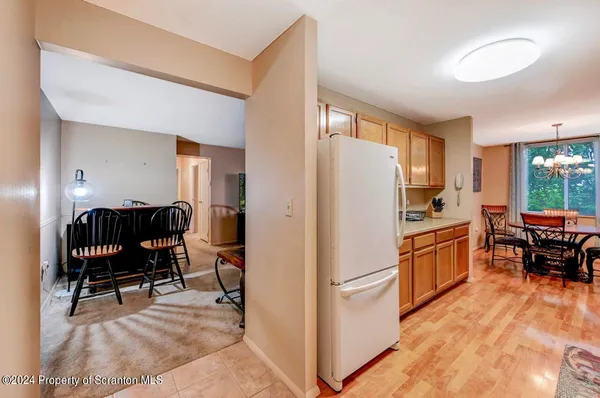 a kitchen with stainless steel appliances granite countertop a refrigerator a stove a dining table and chairs with wooden floor