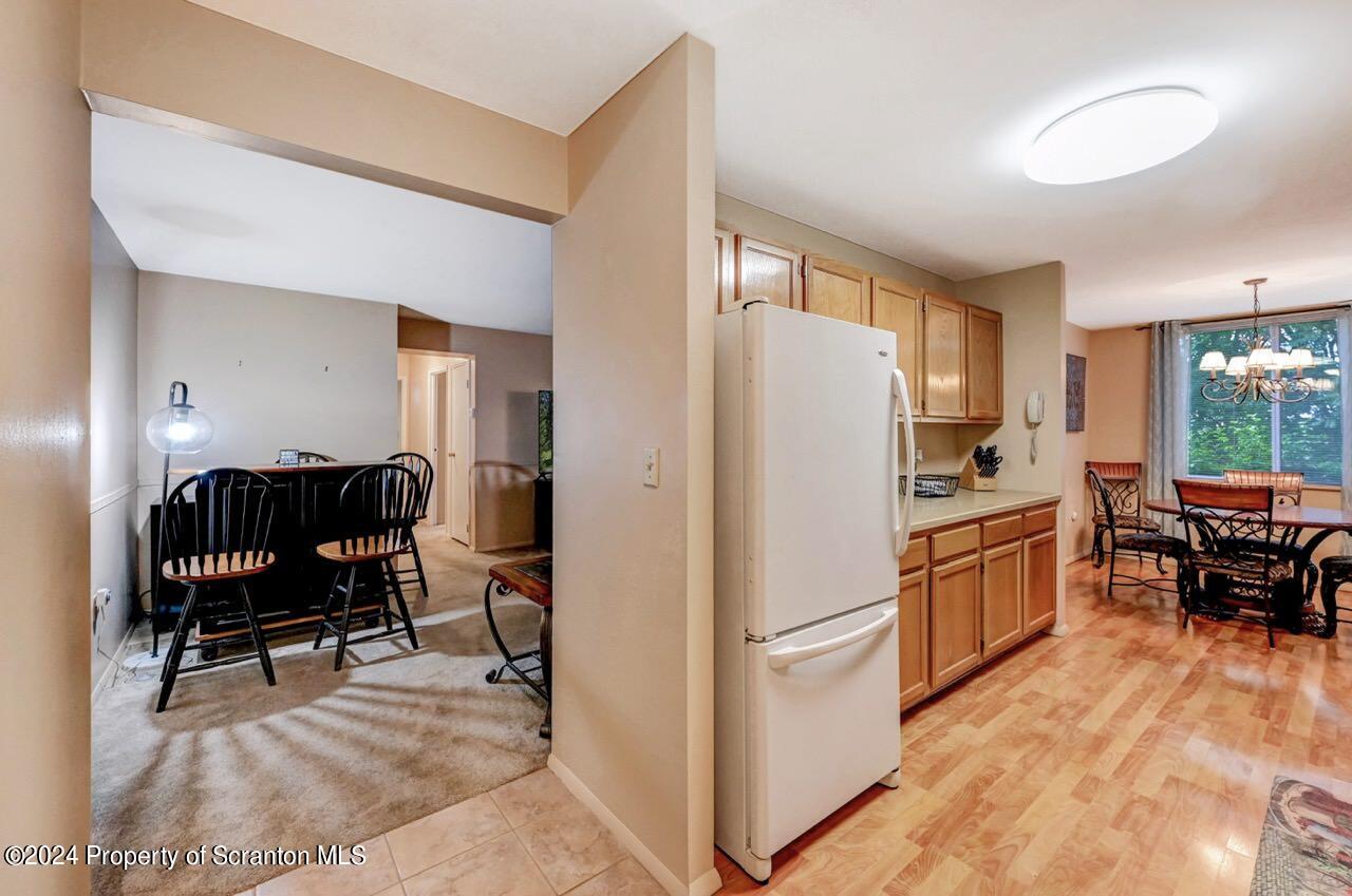 1102 Summit Pointe Scranton, PA 18508 - Photo 6 of 37 a kitchen with stainless steel appliances granite countertop a refrigerator a stove a dining table and chairs with wooden floor