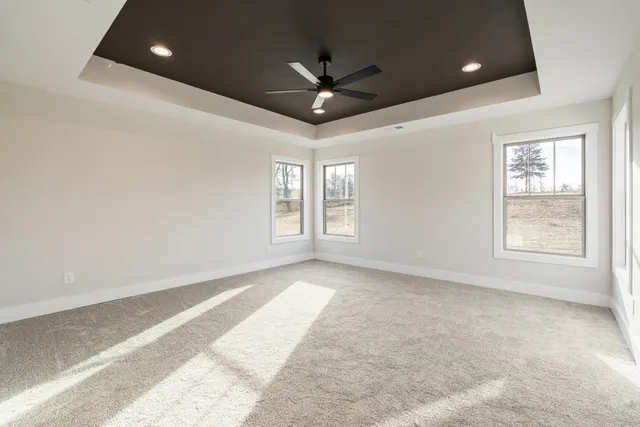an empty room with windows and ceiling fan