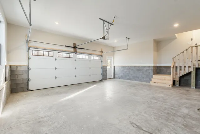 a view of an empty room with a window and kitchen view