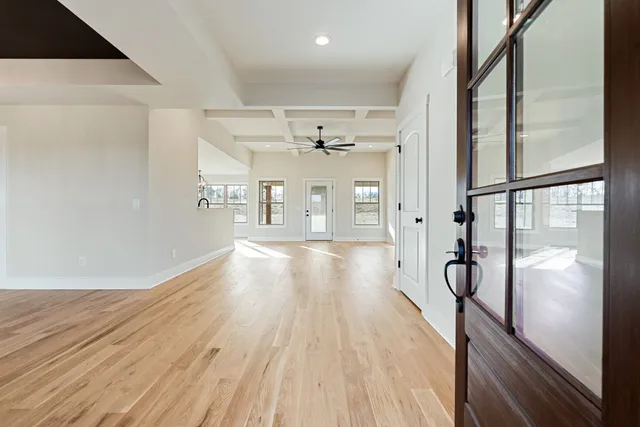 a view of a hallway with wooden floor and chandelier