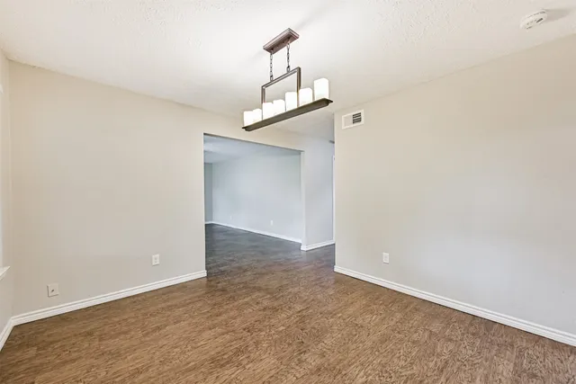 an empty room with a ceiling fan and wooden floor