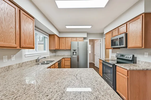 a kitchen with stainless steel appliances granite countertop a stove a sink dishwasher a refrigerator oven with granite countertops and a stove