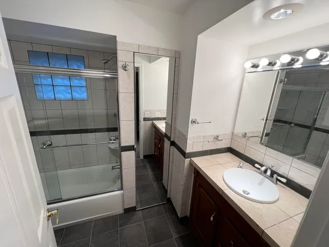 a bathroom with a sink vanity granite toilet and shower