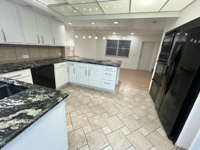 a kitchen with stainless steel appliances granite countertop a sink stove and cabinets