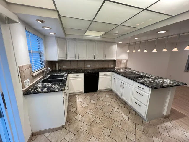 a kitchen with stainless steel appliances granite countertop a stove a sink and a microwave