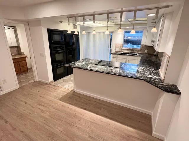 a kitchen with stainless steel appliances granite countertop a refrigerator and a sink