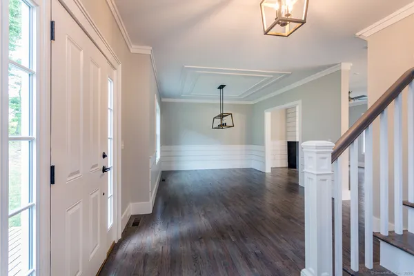 a view of a hallway with wooden floors and stairs