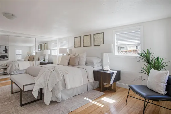 a bedroom with a large bed and windows