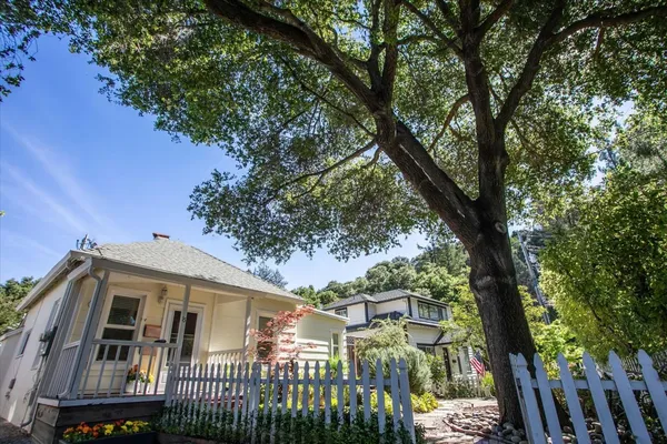 a view of a large white house with large trees