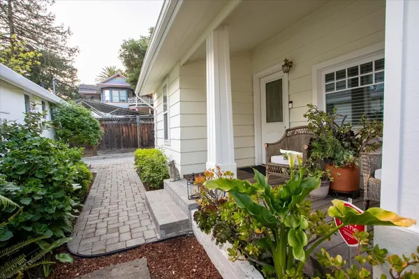 a view of a pathway of house with potted plants