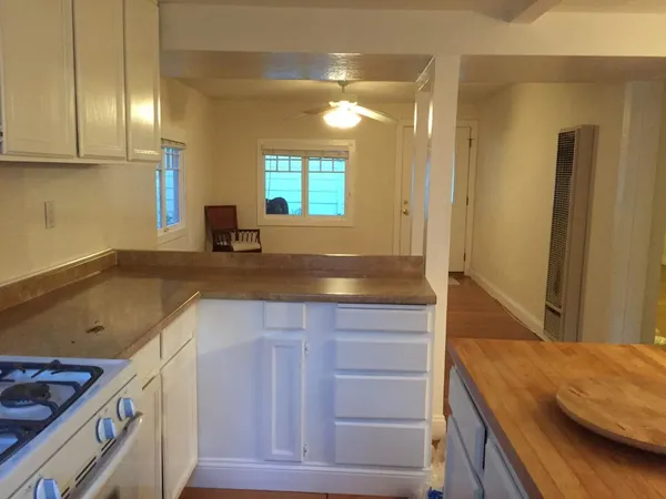 a kitchen with stainless steel appliances granite countertop a table chairs and a refrigerator