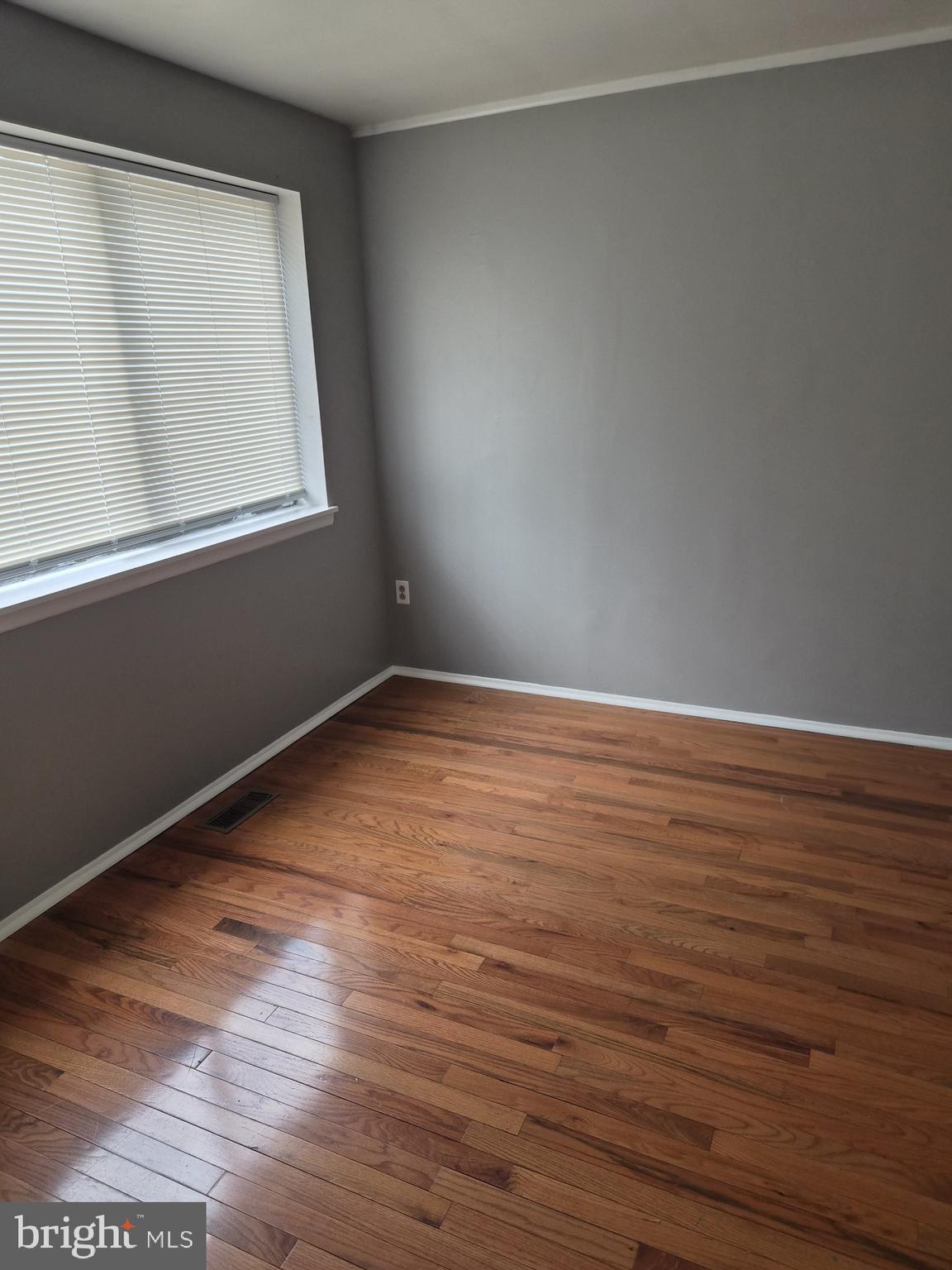 7120 Winter Rose Path Columbia, MD 21045 - Photo 14 of 28 a view of an empty room with wooden floor and a window