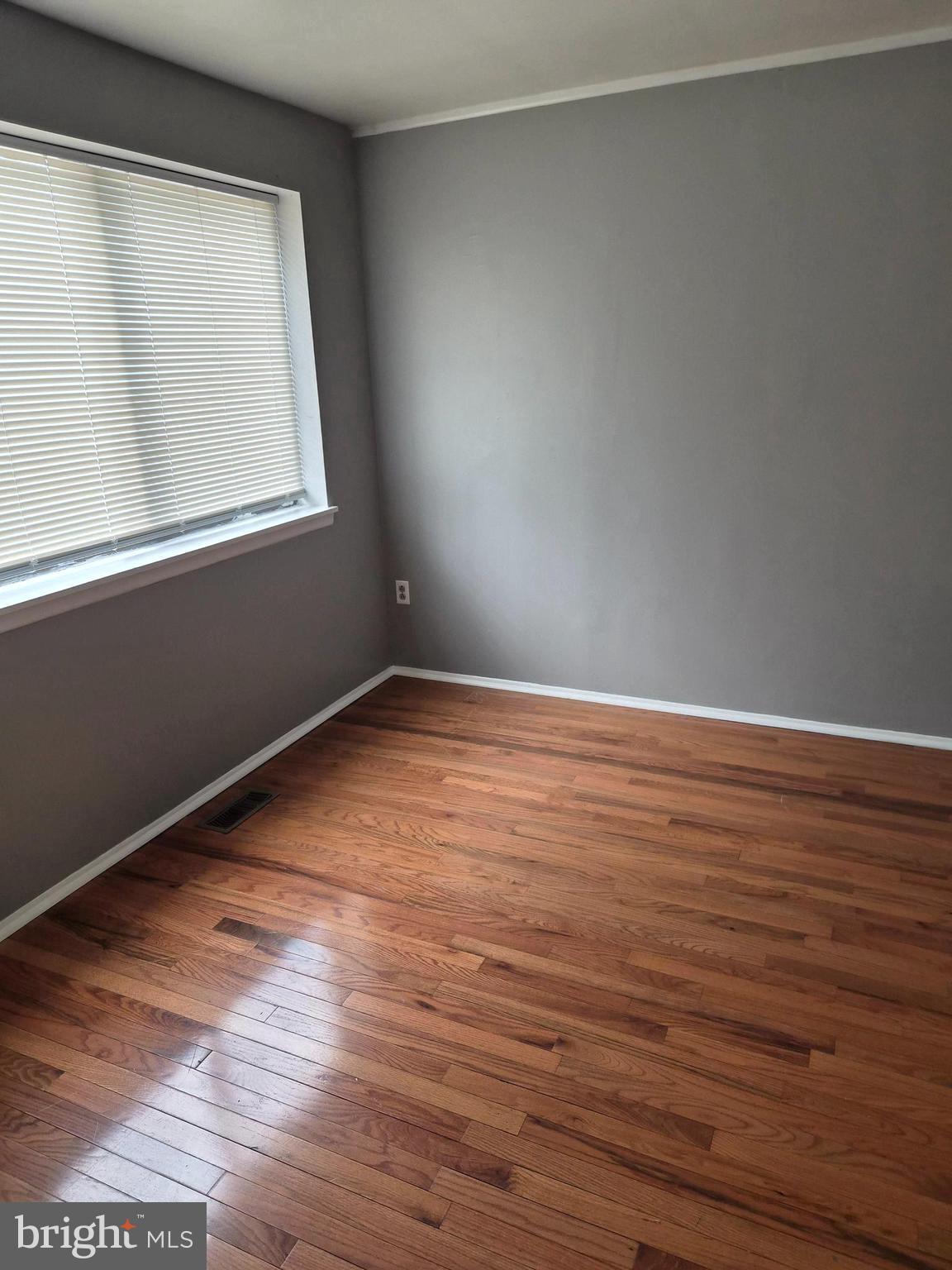 7120 Winter Rose Path Columbia, MD 21045 - Photo 16 of 28 a view of an empty room with wooden floor and a window