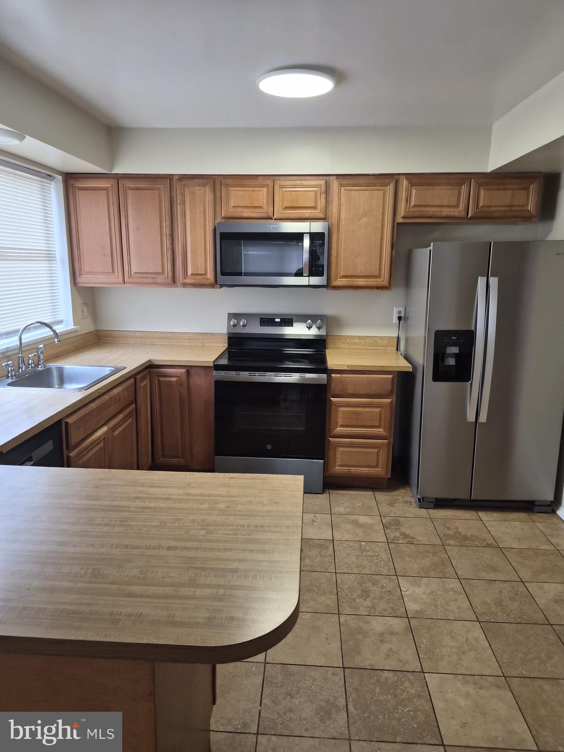 7120 Winter Rose Path Columbia, MD 21045 - Photo 6 of 28 a kitchen with granite countertop a stove a sink and a refrigerator