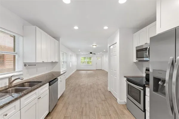 a view of a kitchen with a sink stove and cabinets