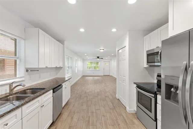 a view of a kitchen with a sink stove and cabinets