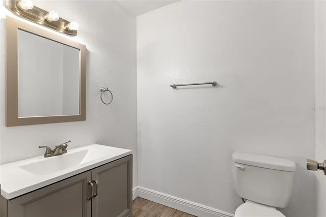 a bathroom with a toilet a sink a mirror and vanity