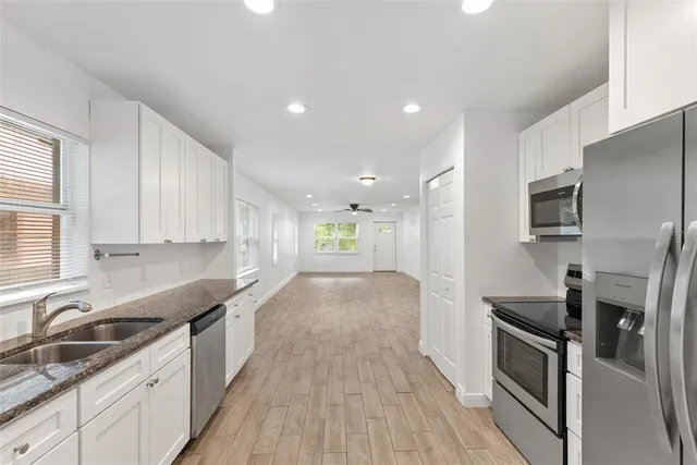 a view of a kitchen with a sink stove and cabinets