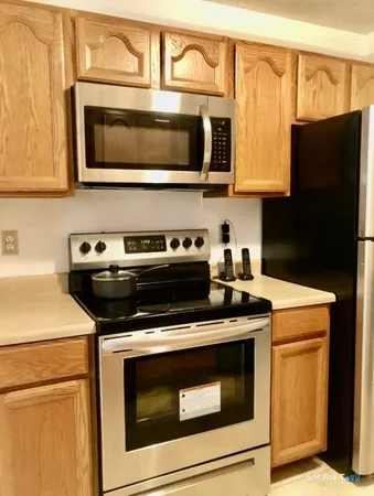 a kitchen with stainless steel appliances granite countertop a stove microwave and refrigerator