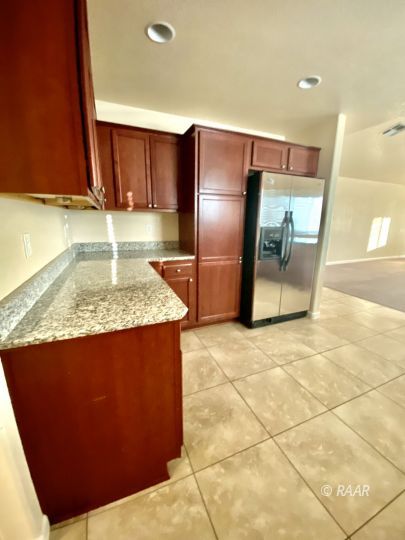 935 West Wasp Avenue Ridgecrest, CA 93555 - Photo 8 of 27 a kitchen with granite countertop a refrigerator a stove and a microwave