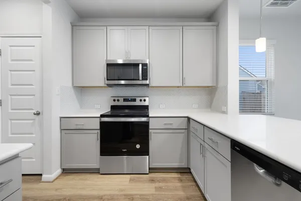 a kitchen with stainless steel appliances a stove microwave and sink