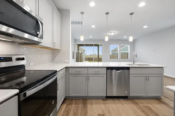 a kitchen with stainless steel appliances granite countertop a stove and a sink