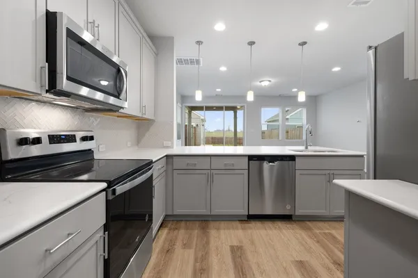 a kitchen with a sink stainless steel appliances and cabinets