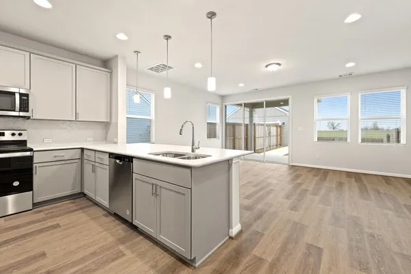 a large kitchen with kitchen island a sink stainless steel appliances and cabinets