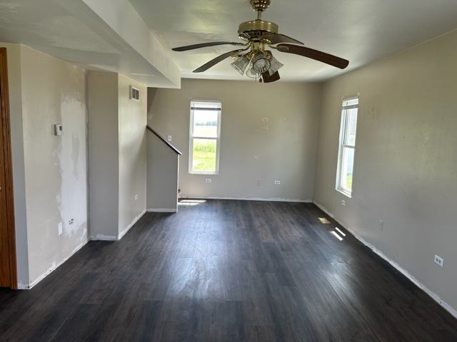741 Sterling Road Dixon, IL 61021 - Photo 4 of 21 an empty room with wooden floor chandelier fan and windows