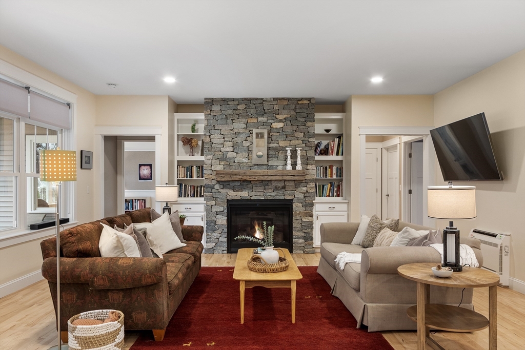 243 Gates Pond Road Berlin, MA 01503 - Photo 12 of 40 a living room with furniture flat screen tv and a fireplace