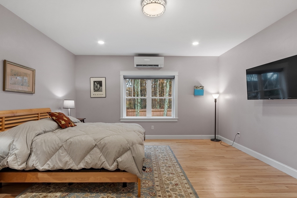 243 Gates Pond Road Berlin, MA 01503 - Photo 21 of 40 a bedroom with a large bed and a flat tv screen on dresser