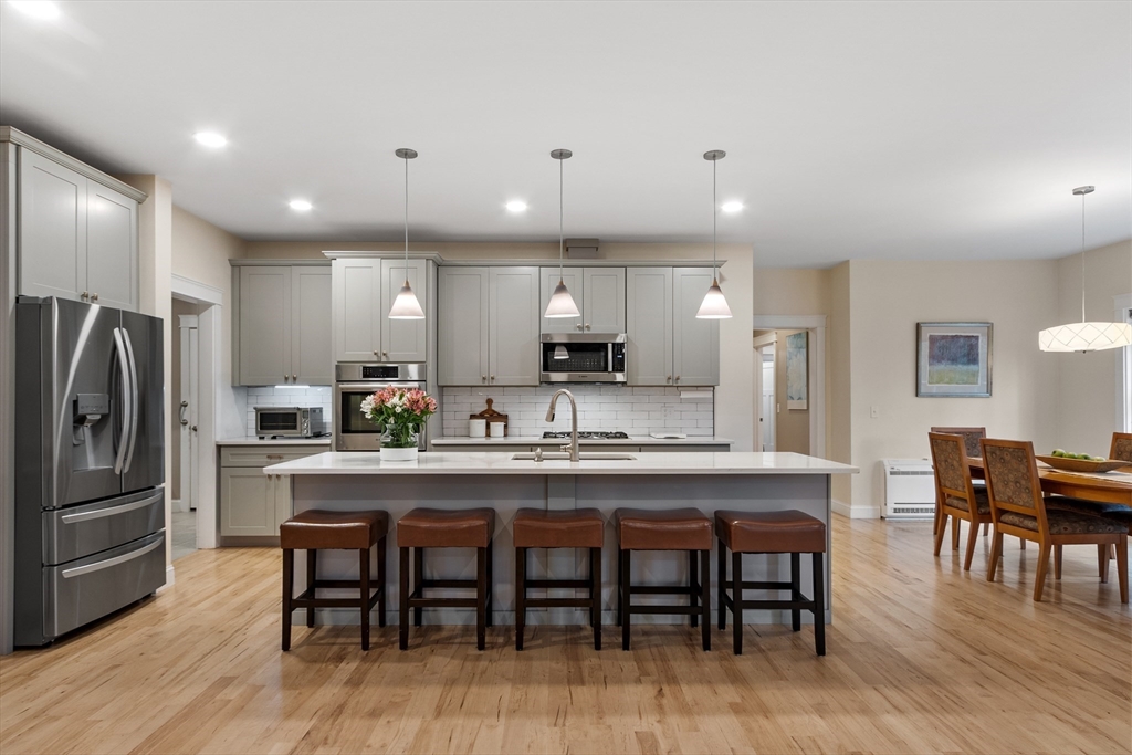 243 Gates Pond Road Berlin, MA 01503 - Photo 8 of 40 a kitchen with kitchen island granite countertop a dining table chairs refrigerator and cabinets