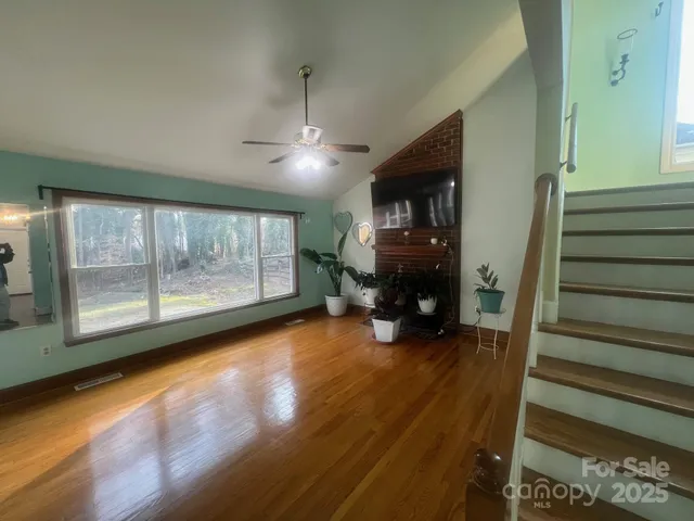a view of empty room with wooden floor and fireplace